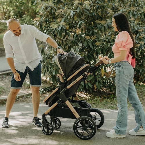 "Ein Vater beugt sich hinunter, um mit seinem kleinen Kind zu interagieren, das im Kinderwagen sitzt.